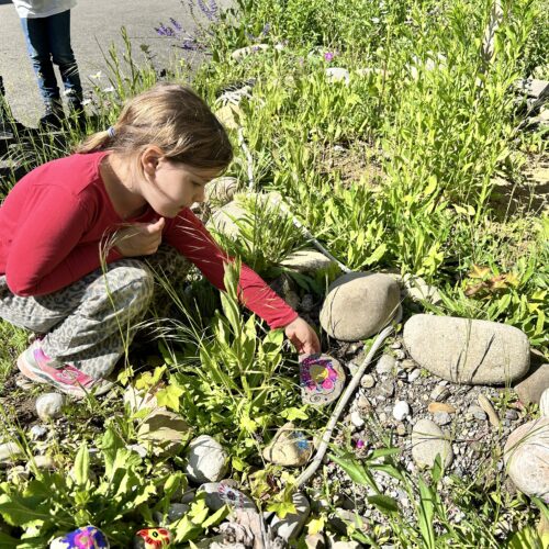 Mädchen legt seinen Stein ins Gras