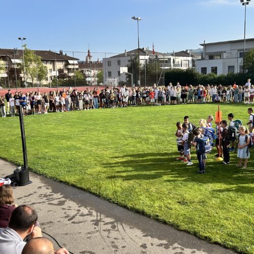 Alle Schüler und Eltern auf dem Rasen versammelt