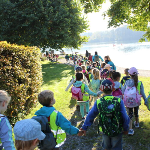 Kinder wandern am See entlang