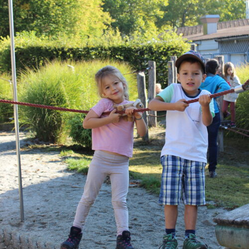 Mädchen und Junge stehen auf Hängebrücke
