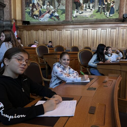 Schüler sitzen stolz auf den Parlamentssitzen