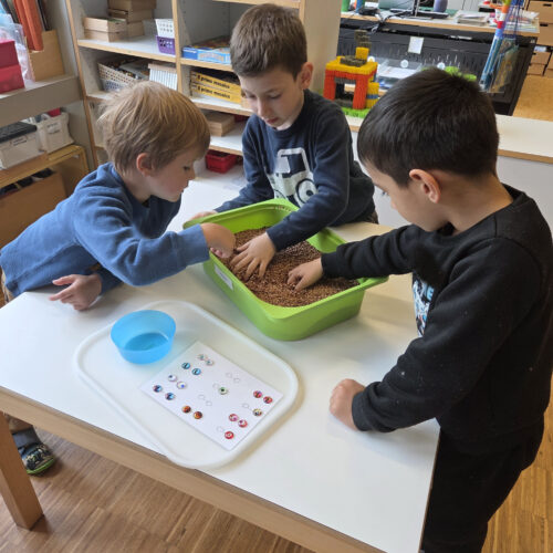 Kinder suchen im mit Linsen gefüllten Topf Teile