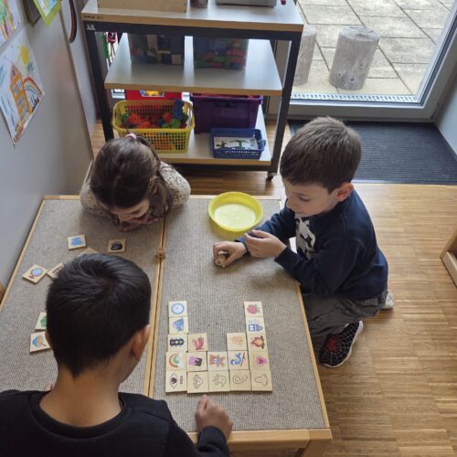 Kinder machen ein Spiel mit Holzbildern