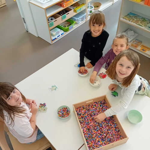 Mädchen machen ein Bügelperlenbild