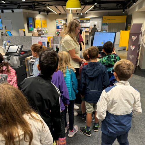 Schüler schauen auf der Post zu.
